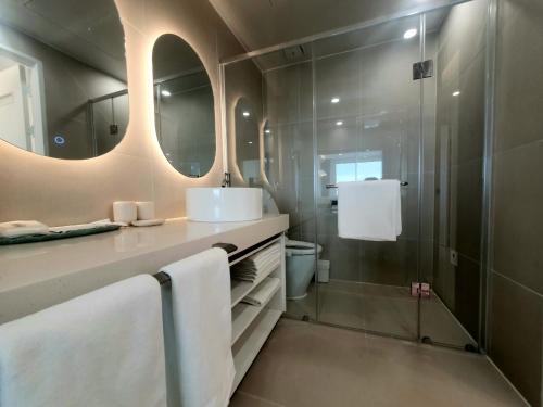 a bathroom with a shower and a sink and mirror at Mr. Slow in Sokcho