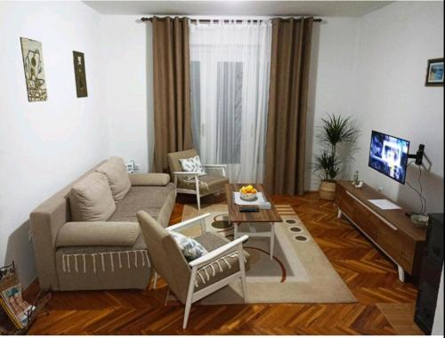 een woonkamer met een bank en een tafel bij Apartman CITRUS Trebinje in Trebinje