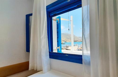 a window with a view of a harbor at Meraki Beachfront in Foinikion