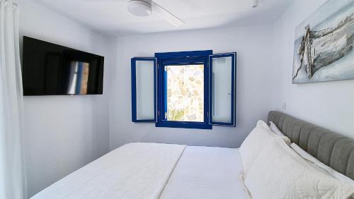 a bedroom with a bed and a window at Meraki Beachfront in Foinikion