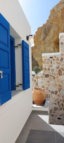 a blue door and a potted plant on a building at Meraki Beachfront in Foinikion