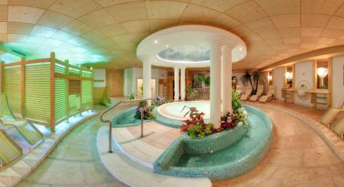 a swimming pool in a building with a swimming poolvisorvisorvisor at Hotel Villa Eden in Corvara in Badia