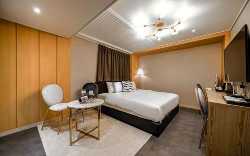 Bay 202 Hotel في بوسان: غرفة فندقية بسرير وطاولة وكراسي