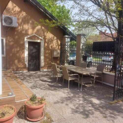 a patio with a table and chairs next to a building at Guest House Maja in Novi Sad