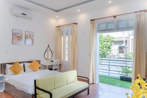 a bedroom with a bed and a couch and a window at Zuchi's Home&Apartment in Da Nang