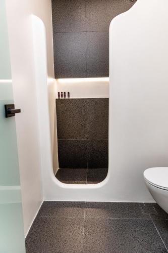 a bathroom with a shower with a glass door at Alenor City Hotel in Naxos Chora