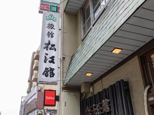 a building with signs on the side of it at Tabist Matsuekan in Matsue