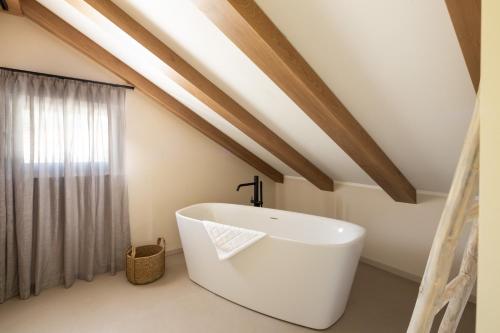 a bathroom with a large white bath tub in a attic at 3 Luxury bedroom Apartment EMMA in Sinj