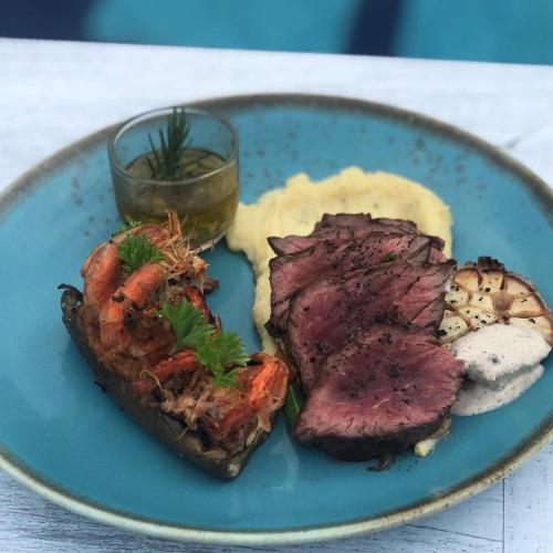 a blue plate of food with meat and other foods at Salt Resort & Spa in Amed