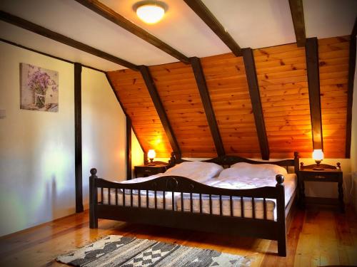 ein Schlafzimmer mit einem Bett in einem Zimmer mit Holzdecken in der Unterkunft Chata Klára in Frymburk