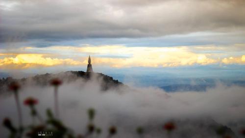 a church on top of a hill in the clouds at วิมานหมอก ภูทับเบิก in Ban Maeo Thap Boek