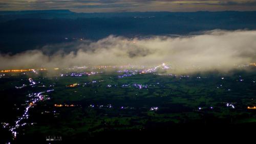 a foggy night view of a city with lights at วิมานหมอก ภูทับเบิก in Ban Maeo Thap Boek