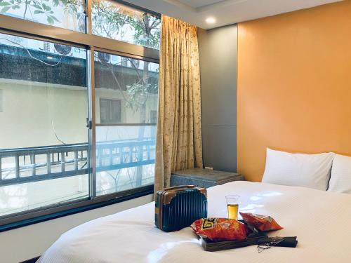 pokój hotelowy z łóżkiem z oknem w obiekcie Spa Spring Resort w Tajpej