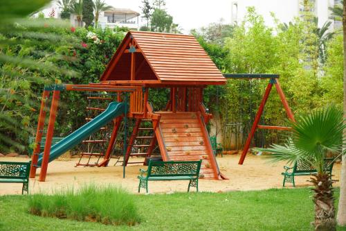 a playground with a house and a slide at Odyssee Park Hotel in Agadir