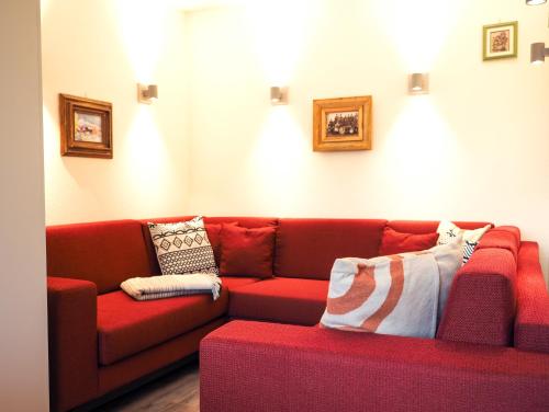 a red couch in a living room with pillows at Chesa Montana in Maria Alm am Steinernen Meer