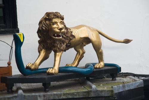 a statue of a lion standing on a surfboard at The New Inn by Roomsbooked in Gloucester