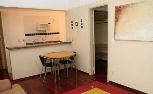 una pequeña cocina con mesa y sillas en una habitación en Imperial Suzano Shopping Hotel en Suzano