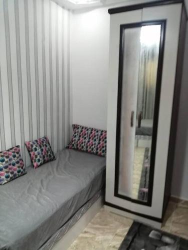 a small bed with a mirror in a room at Sea spirit in Alexandria