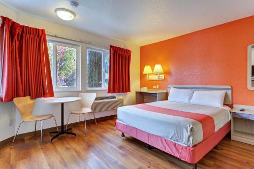 a hotel room with a bed and a table and chairs at Motel 6-Rohnert Park, CA in Rohnert Park