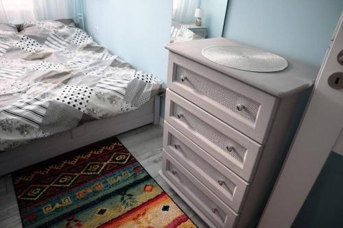 sypialnia z łóżkiem i komodą ze zlewem w obiekcie Uroczy Apartament- Kołobrzeg w Kołobrzegu