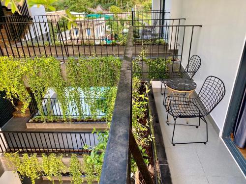 a balcony with a table and chairs and plants at Fati Boutique Hotel & Apartment in Vung Tau