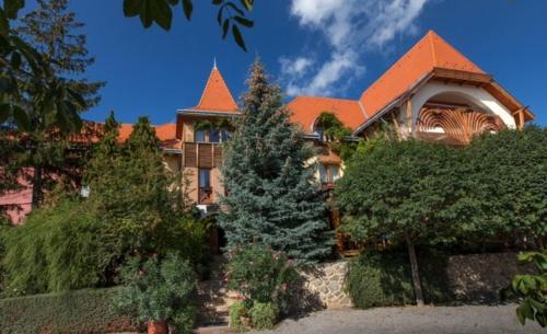 a large house with an orange roof at Bagolyvár Panzió in Pécs