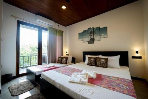 1 dormitorio con 2 camas y ventana grande en Mihisara Resort en Anuradhapura