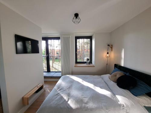 sypialnia z dużym łóżkiem i 2 oknami w obiekcie Seaside Apartment at Albatross resort w mieście Ķesterciems
