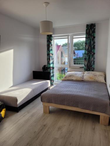 a bedroom with two beds and a window at Pensjonat Markus Grzybowo in Grzybowo