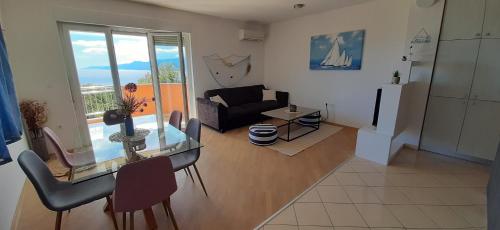 a living room with a glass table and a couch at Apartman Kos in Zamet