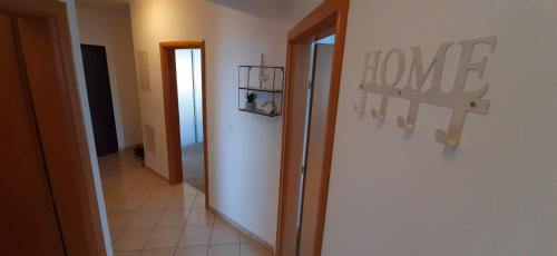 a hallway with a home sign on a wall at Apartman Kos in Zamet