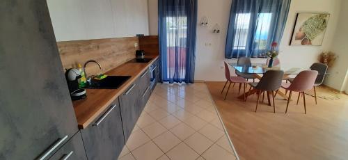 a kitchen and dining room with a table and chairs at Apartman Kos in Zamet