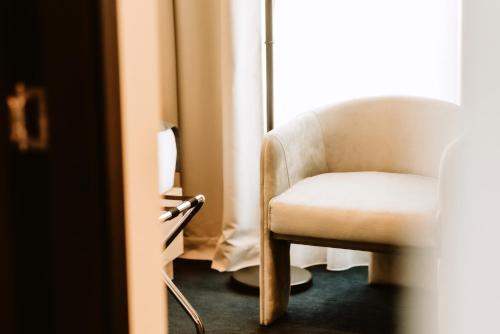 a chair in a room with a window at Hotel Septembar in Podgorica