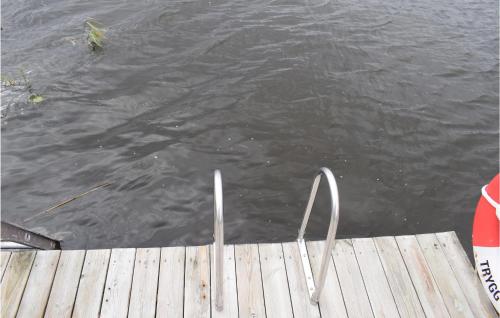 a wooden dock with a metal object in the water at Nice Apartment In Tranås in Tranås