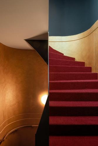 a red carpeted staircase in a building at Legend Hotel in Cologne