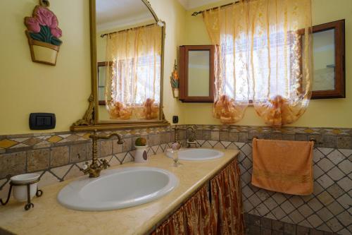 a bathroom with two sinks and two mirrors at Casa vacanza Il Giglio in Manduria