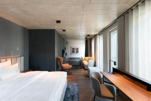 a bedroom with a large bed and a desk at Legend Hotel in Cologne