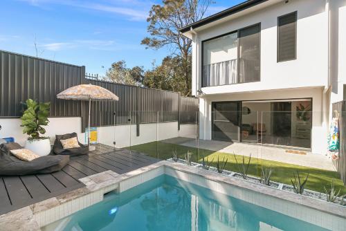 una casa con piscina di fronte a una casa di Grandview Villa Kingscliff - Oceanview Tri-level Villa by uHoliday a Kingscliff