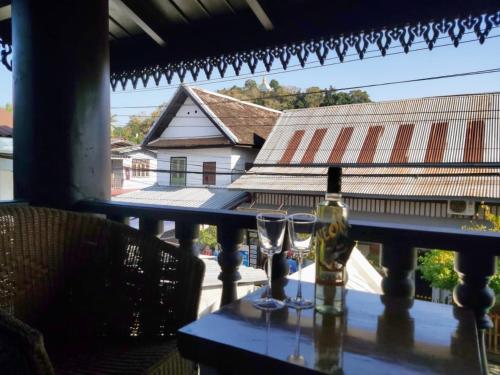 einen Tisch mit zwei Gläsern und einer Flasche Wein in der Unterkunft Mali House in Luang Prabang