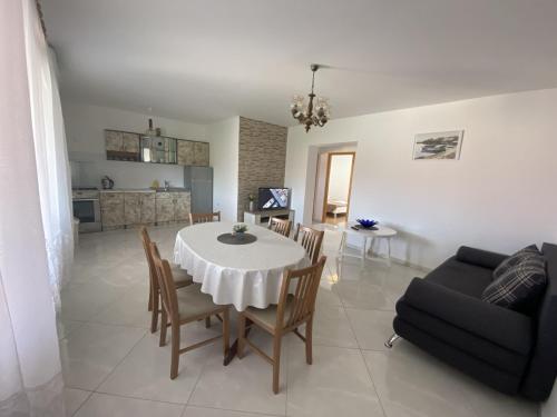 uma sala de jantar e sala de estar com mesa e cadeiras em Apartments Zvonimir em Privlaka