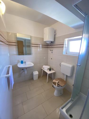 a bathroom with a toilet and a sink at Apartments Zvonimir in Privlaka