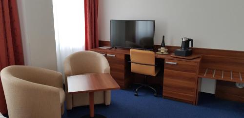 a room with a desk with a television and two chairs at Wellness & SPA Lipno - Frymburk C410 in Frymburk
