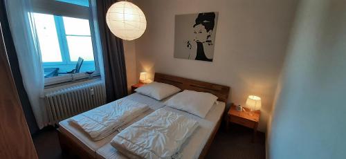 um pequeno quarto com uma cama e uma janela em Haus des Kurgastes Haus des Kurgastes 1 em Heiligenhafen