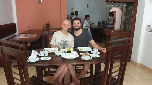 um homem e uma mulher sentados à mesa com comida em Hotel Savonrich em Anuradhapura