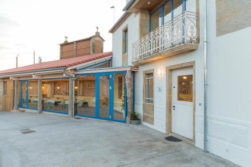 a building with blue doors and a balcony at Luz de Viro in Outes