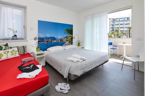 1 dormitorio con 2 camas y sofá rojo en Casa al Lago, en Riva del Garda