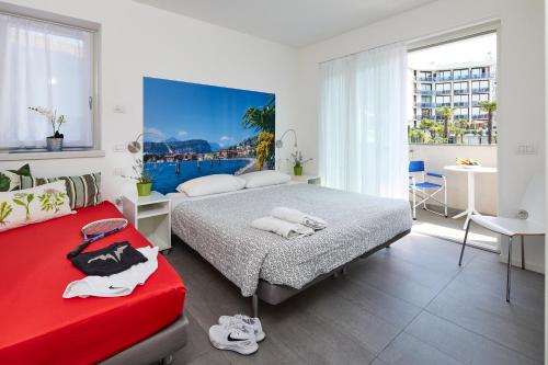 a bedroom with two beds and a red couch at Casa al Lago in Riva del Garda