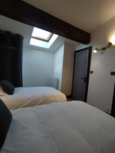 a bedroom with two beds and a skylight at Chalet Appart'Hôtel l'Eau Vive in Saint-Nicolas-la-Chapelle