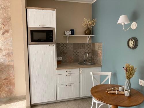 une cuisine avec une armoire blanche et une table dans l'établissement Detente de la lys, à La Gorgue