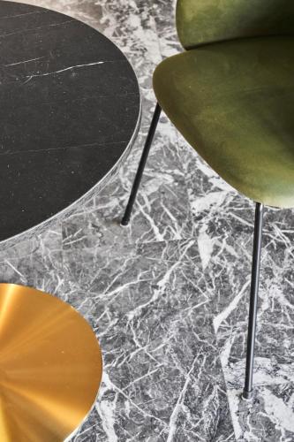 a green chair and a table on a marble floor at Hotel Astoria in Garda
